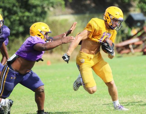 Columbia receiver Camdon Frier runs up the field after a catch as linebacker Wilson Philemon gives chase during Friday’s scrimmage. (JORDAN KROEGER/Lake City Reporter)