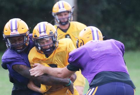 Columbia receiver Bynton Edge (middle) is tackled by defensive back Mickell Rivers (left) and defensive end Ayden Phillips (right) after a catch during Tuesday’s practice. (JORDAN KROEGER/Lake City Reporter)