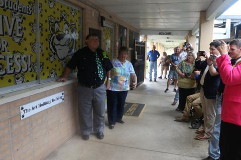 Art Holliday, a former Summers Elementary principal, stands next to the sign for the ‘Art Holliday Building’ at the school on Tuesday. (MORGAN MCMULLEN/Lake City Reporter)