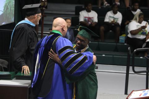 FGC student speaker Tavion Taylor (right) hugs FGC President Larry Barrett after receiving his Associate in Arts degree during Thursday’s graduation ceremony. (MORGAN MCMULLEN/Lake City Reporter)