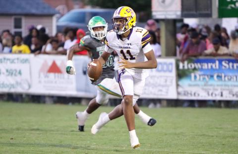 Columbia quarterback Zack Paulk scrambles away from Suwannee defensive end Ja’Darius Cherry during Friday’s Preseason Classic. (BRENT KUYKENDALL/Lake City Reporter)