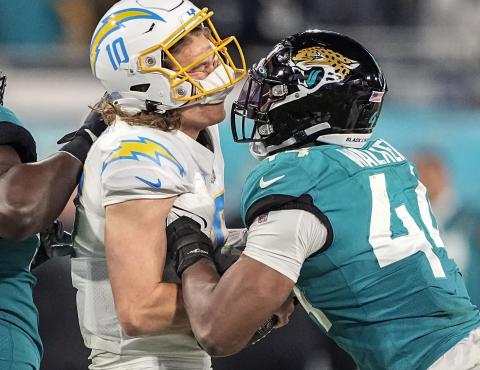 Los Angeles Chargers quarterback Justin Herbert is hit by Jacksonville Jaguars linebacker Travon Walker during their wild-card playoff game on Jan. 14 in Jacksonville. (CHRIS CARLSON/AP File)