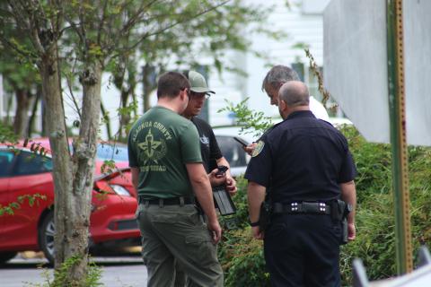 Members of the Alachua County Bomb Squad and Lake City Police Department look at the suspicious device found in the Quality Inn on Thursday morning. (JAMIE WACHTER/Lake City Reporter)