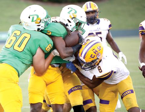 DeLand running back Ladamion Bletcher tries to power through Columbia defenders, including Markeyon Moore (8) on Friday night at Spec Martin Memorial Stadium. (BRENT KUYKENDALL/Lake City Reporter)