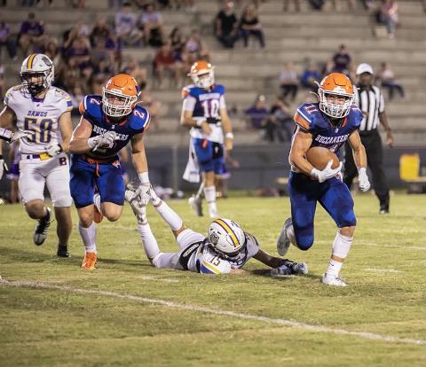 Branford receiver Austin Malaguti runs past a Bell defender Saturday night during the Buccaneers’ 40-0 win. (ERIN ROBERTS/Special to the Reporter)