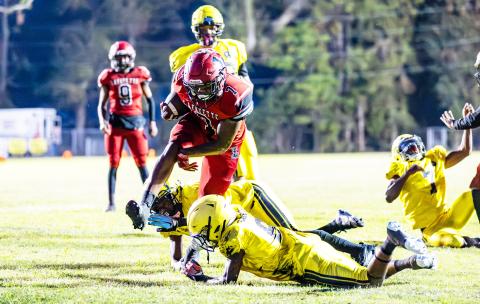 Lafayette running back Jamarien Ervin leaps over a Zarephath Academy defender on Friday. (JACK HOWDESHELL/Special to the Reporter)