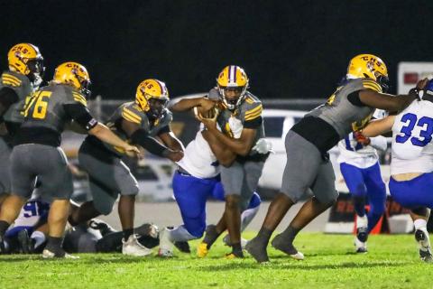 Columbia quarterback Zack Paulk tries to escape pressure from the Trinity Christian defense on Friday night. (BRENT KUYKENDALL/Lake City Reporter)