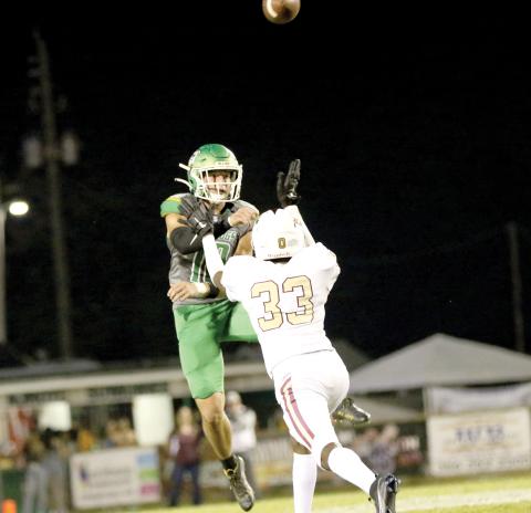 Suwannee quarterback Kodi Lang throws a pass while being pressured by Jordan McDonald last Friday. (JAMIE WACHTER/Lake City Reporter)