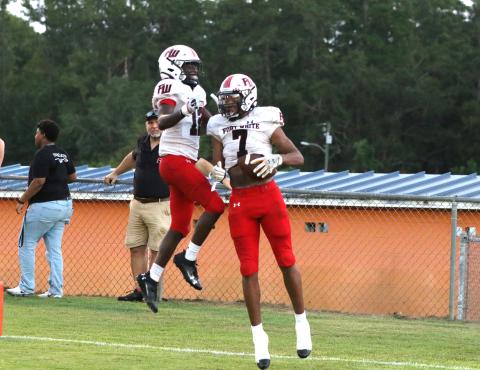 Fort White receivers Tafari Moe (7) and Najeeb Smith celebrate after Moe's third touchdown reception Monday night at Jefferson County. (MORGAN MCMULLEN/Lake City Reporter)