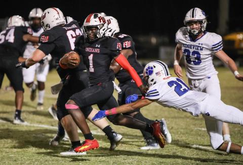 Fort White running back Dakota Fisher races past a Ridgeview defender on Friday.  (BRENT KUYKENDALL/Lake City Reporter)