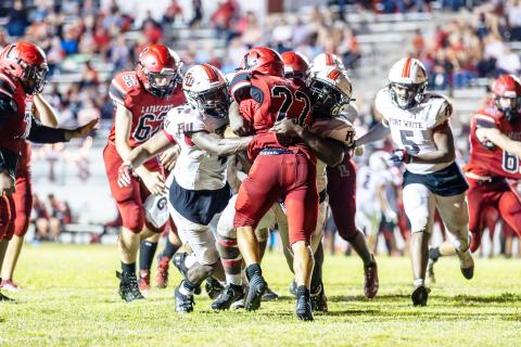 Maliki Clark (4) and the Fort White defense tackle Lafayette running back Tavis Hutson last Friday. (JACK HOWDESHELL/Special to the Reporter)