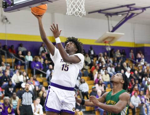 Columbia forward Zavian Douglas makes a layup ahead of Suwannee’s Ja’Darius Cherry on Tuesday. (BRENT KUYKENDALL/Lake City Reporter)