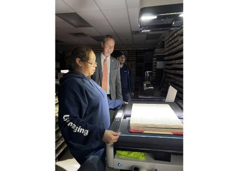 Columbia County Clerk of Court Jay Swisher (center) watches as U.S. Imaging’s Felicia Valdez scans one of the county’s bound historical records in the records vault at the Columbia County Courthouse Thursday. U.S. Imaging’s Brandon Valdez looks on. (JAMIE WACHTER/Lake City Reporter)