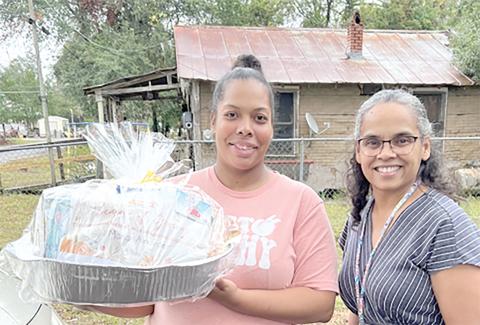 Nilda Soto, a family support specialist with the Early Learning Coalition of Florida’s Gateway, delivers a meal to Maria Alexander, a Season of Giving recipient, earlier this month. (COURTESY)