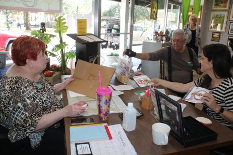 Brenda Kennedy (clockwise, from left), Art League of North Florida board secretary, John Larner and Sheila Carr, Gateway Art Gallery Curator, organize entries that have been submitted for the Gateway Art Gallery’s Christmas ornament decoration contest. (TONY BRITT/Lake City Reporter)