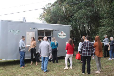 A line waits at the Cluckin’ and Truckin’ food truck at The Foundation for Florida Gateway College Giving Day campaign event Tuesday. (TONY BRITT/Lake City Reporter)