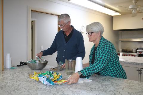 Bob Smith and Jeannie McGalliard, Parkview Baptist Church cold weather shelter volunteers, put out snacks for clients utilizing the facility on Tuesday night. (TONY BRITT/Lake City Reporter)