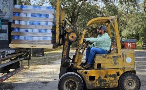 One of the six pallets of paint, donated by Kelly-Moore Paints in partnership with the Global Empowerment Mission), are unloaded at the Lafayette County Emergency Operations Center in Mayo. (COURTESY GEM)