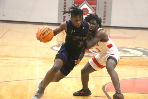 Columbia guard Zamarion Jones drives past Santa Fe’s NyShaun Jenkins on Friday night. (MORGAN MCMULLEN/Lake City Reporter)