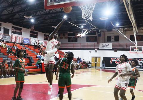 Fort White guard Jayden Jackson makes a layup over Eastside forward Davion Pugh on Friday night. (MORGAN MCMULLEN/Lake City Reporter)