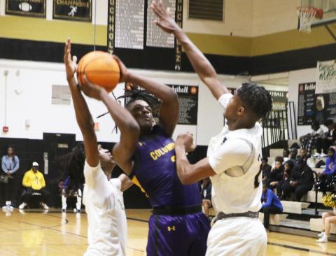 Columbia guard Zamarion Jones drives to the basket between two Buchholz defenders on Tuesday night. (MORGAN MCMULLEN/Lake City Reporter)