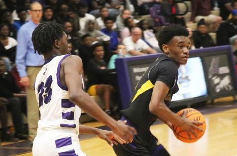 Columbia guard Bobby Wilson looks for a driving lane while being defended by Gainesville guard Willie Brooks on Tuesday. (JORDAN KROEGER/Lake City Reporter)