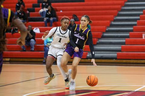 Columbia guard Mariah Cox is dribbles while being defended by Fort White forward Isreal Hart on Monday night. (BRENT KUYKENDALL/Lake City Reporter)
