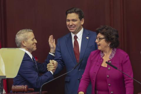 Florida Gov. Ron DeSantis is welcomed to a joint session of the Senate and House of Representatives by House Speaker Paul Renner, left, and Florida Senate President Kathleen Passidomo, right, to give his State of the State address in Tallahassee on Tuesday. (GARY MCCULLOUGH/Associated Press)