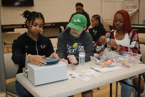 Zamaria Granado (from left) and Hunter Neeley work on making dog tag necklaces for Florida Gateway College students on Wednesday morning. The necklace-making sessions and other activities were part of the school’s welcome back activities for the spring semester. (TONY BRITT/Lake City Reporter)