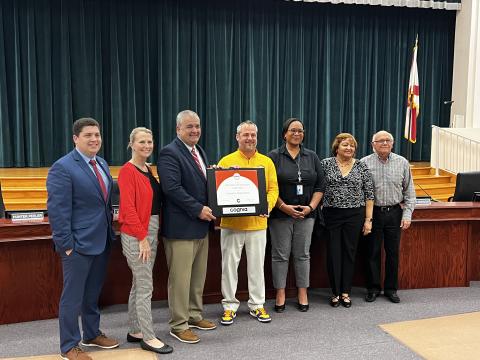 Columbia High Principal Trey Hosford (middle) is presented a framed certificate in honor of the school having 100 years of continuous accreditation. Joining Hosford are School Board members Hunter Peeler (from left) Dana Brady-Giddens, Superintendent Lex Carswell, Assistant Superintendent Hope Jernigan, Narrie Smith and Keith Hudson. (JAMIE WACHTER/Lake City Reporter)