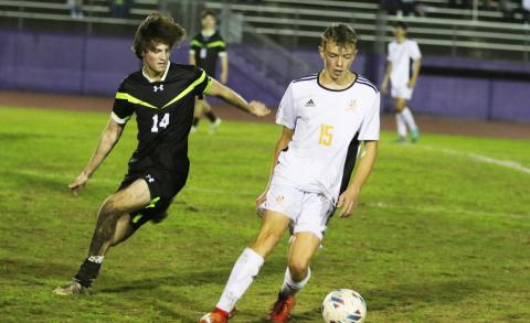 Columbia midfielder Bobby Shotwell (left) battles with Orange Park midfielder Andrew Gardiner for possession Friday night. (MORGAN MCMULLEN/Lake City Reporter))