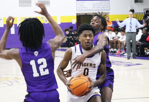 Columbia guard Noah Wilson drives to the basket as Gainesville guard Brendan Bloodworth (12) and guard Willie Brooks (right) defend on Saturday night. (JORDAN KROEGER/Lake City Reporter)