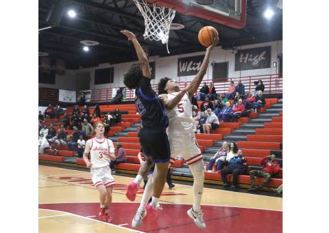 Fort White guard Tafari Moe goes for a layup against Newberry's Kai Washington during Thursday's game. (MORGAN MCMULLEN/Lake City Reporter)