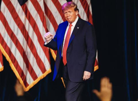 Former President Donald Trump pumps his fist as he enters to speak at a caucus night watch party at Treasure Island on Thursday in Las Vegas. (Madeline Carter/Las Vegas Review-Journal/TNS)