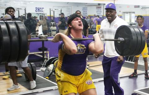 Columbia lifter Caden Bolstein raises the bar up for the clean and jerk while head coach Brian Allen yells encouragement during Wednesday’s tri-meet against Buchholz and Hamilton County. (JORDAN KROEGER/Lake City Reporter)