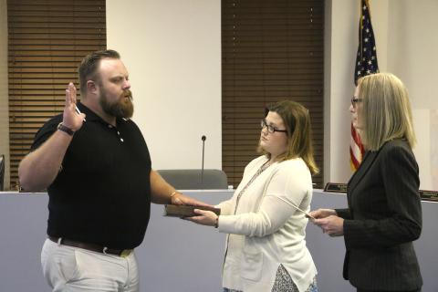 James Carter (left) is sworn in as a member of the Lake City Council by City Clerk Audrey Sikes (right) on Monday night after being appointed to the District 13 seat. Carter’s wife, Jenna, holds the Bible for the ceremony. (MORGAN MCMULLEN/Lake City Reporter)
