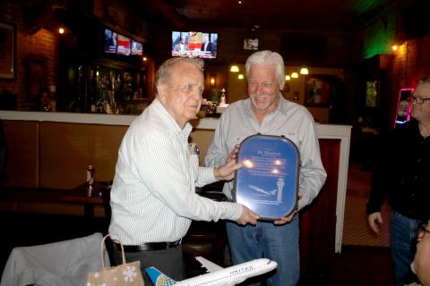 Bo Hendrick (left), who has worked at the Lake City Gateway Airport for more than 59 years, receives a gift Tuesday from Loren Triefenback from United Airlines. (TONY BRITT/Lake City Reporter)