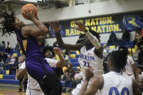 Columbia forward Jalen Gaskins tries to get a shot up over Rickards forward Tarek Caesor during Thursday’s Region 1-5A quarterfinal. (JORDAN KROEGER/Lake City Reporter)