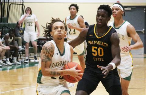 FGC guard Jazan Johnson drives past Palm Beach State guard Devontre Chaney for a basket on Jan. 17. (JORDAN KROEGER/Lake City Reporter)