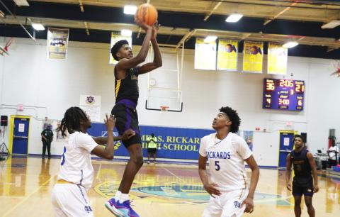 Columbia guard Noah Wilson shoots while defended by Rickards guard Chadwick Ellenwood (left) and forward Benjamin Plummer (5) during the District 2-5A championship on Saturday. (MORGAN MCMULLEN/Lake City Reporter)
