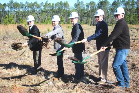 AgroLiquid adminstrators David Gilliam (from left), Gerrit Bancroft, Nick Bancroft, Alan Kennedy and Todd Cressman toss dirt from their shovels during  Tuesday morning’s groundbreaking ceremony for the new AgroLiquid plant at the North Florida Mega Industrial Park. (TONY BRITT/Lake City Reporter)
