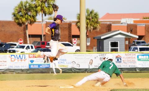 Columbia shortstop Grant Bowers jumps high for a throw as Venice runner Maddox Volk slides safely into second base on Tuesday. (BRENT KUYKENDALL/Lake City Reporter)