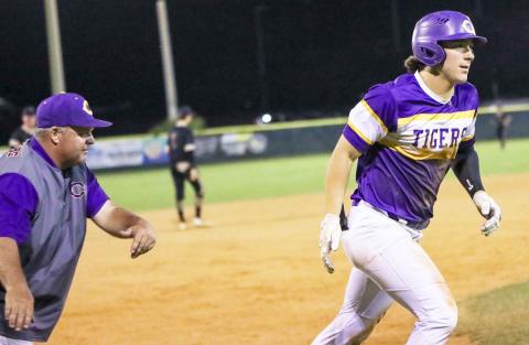 Columbia third baseman Ayden Phillips (right) heads to home plate after being congratulated by head coach Chris Howard following a home run against St. Augustine on Tuesday night. The game was postponed in the fourth with the Tigers leading 10-2 due to the lights in the outfield going out. (BRENT KUYKENDALL/Lake City Reporter)