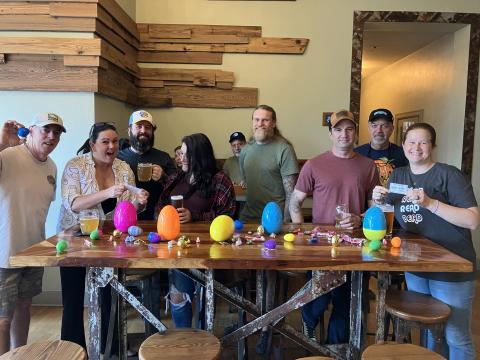 The team of the Chief’s Council Members — Halpatter’s Mug Club — assemble Easter eggs for Saturday’s hunt. Douglas Weisberg (from left), Kristen Jones, Tim Jones, Lindsey Strickland, Casey Woods, Ryan Scuglia, Glenn Rasmussen and Heidi Scuglia put together roughly 3,000 eggs filled with candy and local coupons for the event. (COURTESY)