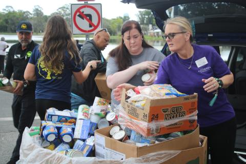 Shannon Moser (from left), Catholic Charities Lake City Regional Director, and Renee LeBlanc fill a box with canned goods and other food items donated by Circle of Life Assisted living facilities. Catholic Charities held its March Against Hunger Walk on Tuesday afternoon at Lake DeSoto. (TONY BRITT/Lake City Reporter)