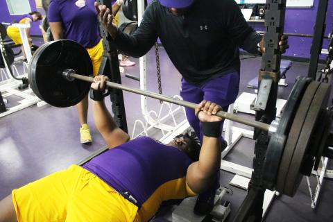 Columbia lifter Chase Johnson performs the bench press while head coach Brian Allen spots him during Wednesday’s meet against Madison County. (JORDAN KROEGER/Lake City Reporter)