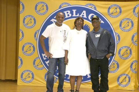 Niblack Elementary alumni Conrad Wallace (from left), Vallice Caldwell and Ronald Griffin gather on the stage in the Niblack cafeteria during Thursday’s tour. (MORGAN MCMULLEN/Lake City Reporter)