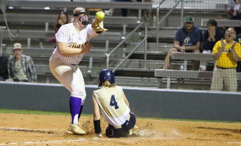 University Christian second baseman Alyssa Smith scores on a passed ball ahead of a throw to Columbia pitcher Josie Raulerson on Friday night. (BRENT KUYKENDALL/Lake City Reporter)