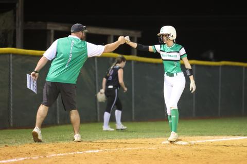 Suwannee head coach Greg Gabey (left) fist bumps Rachel Smith after she reached third base against Gainesville on April 12. (PAUL BUCHANAN/Special to the Reporter)