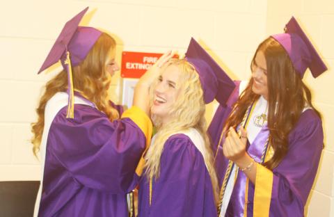 Ansley Williams (from left) adjusts Elle Grecian’s cap as Kansas Schrader also makes last minutes adjustments to Grecian’s outfit in the minutes leading up to Friday evening’s graduation at Columbia High School. (TONY BRITT/Lake City Reporter)